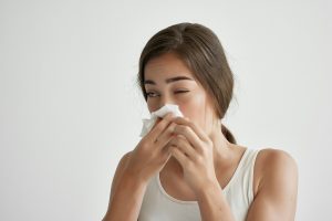A,woman,sneezes,an,allergy,disease.